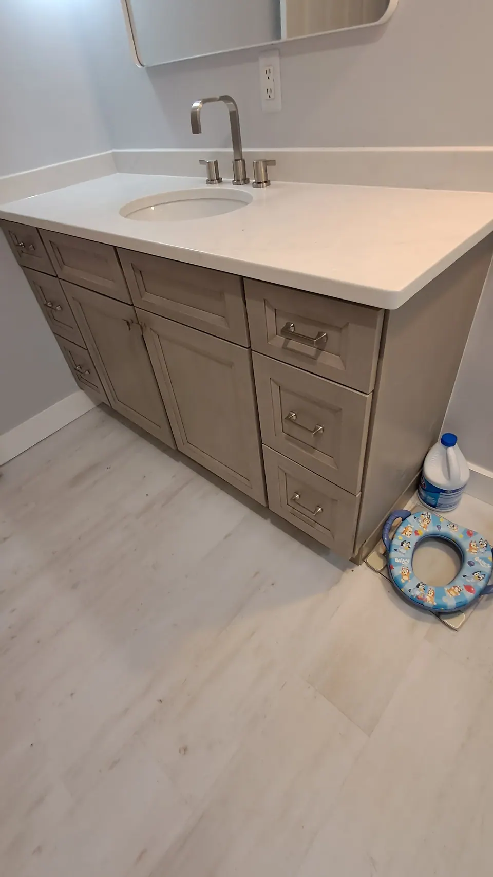 Greige shaker vanity with drawer stacks and a white top, seen from the side.