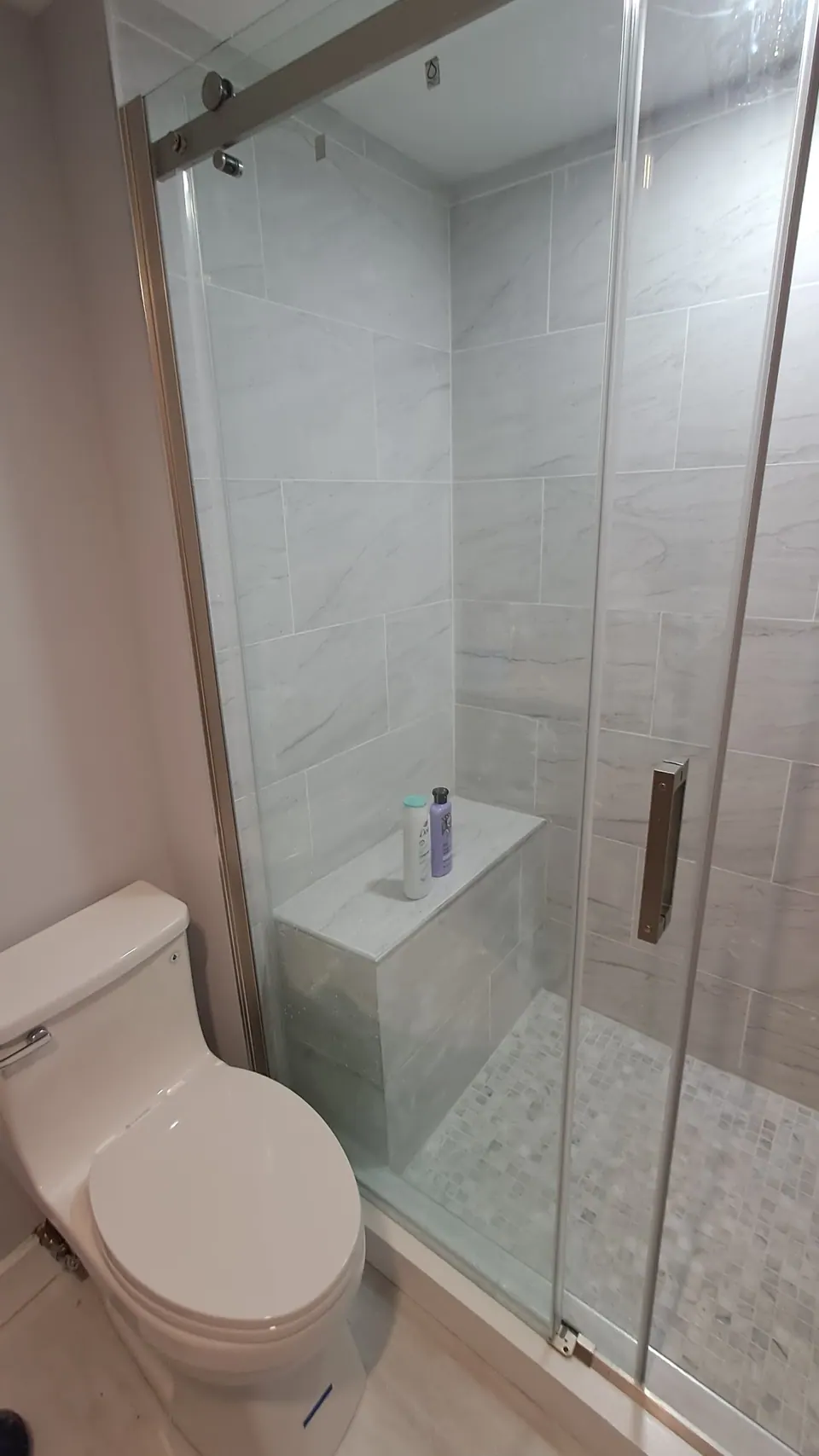 Shower bench behind the sliding glass door.