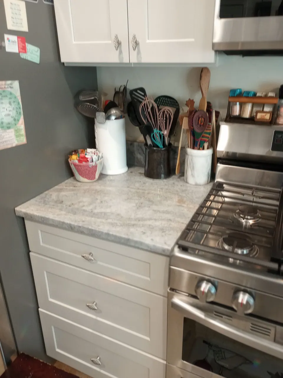 Light gray drawer base next to the range with a stone-look counter.
