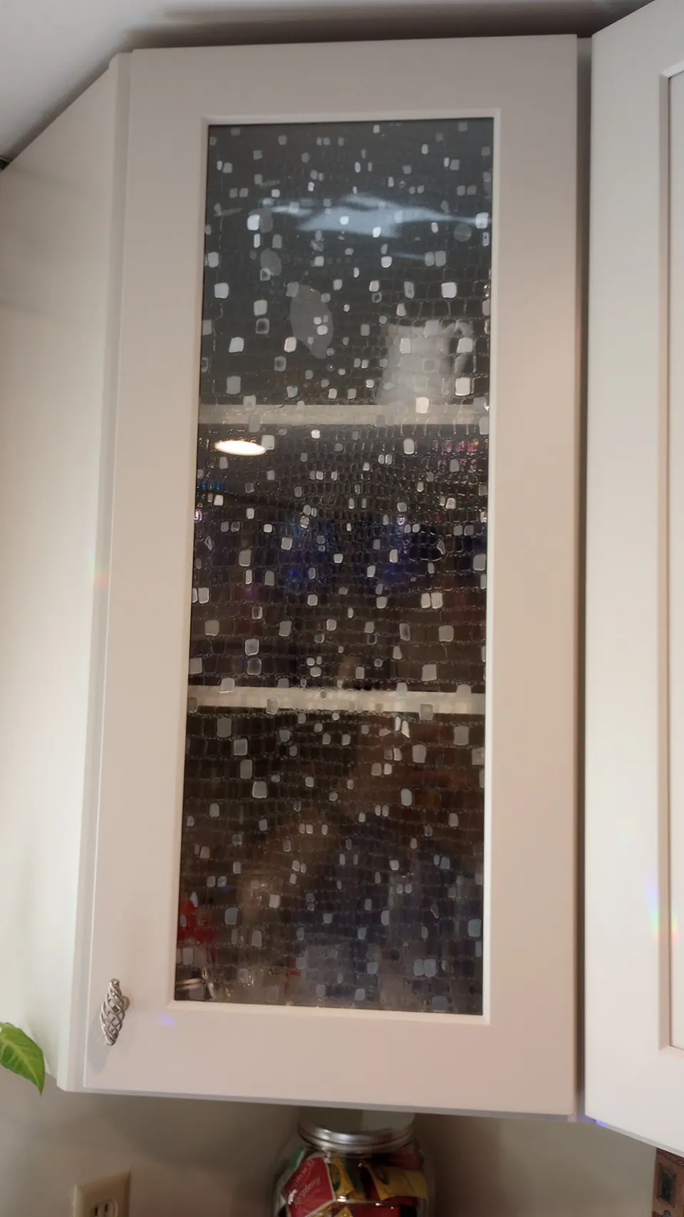 Glass-front wall cabinet with seeded glass.