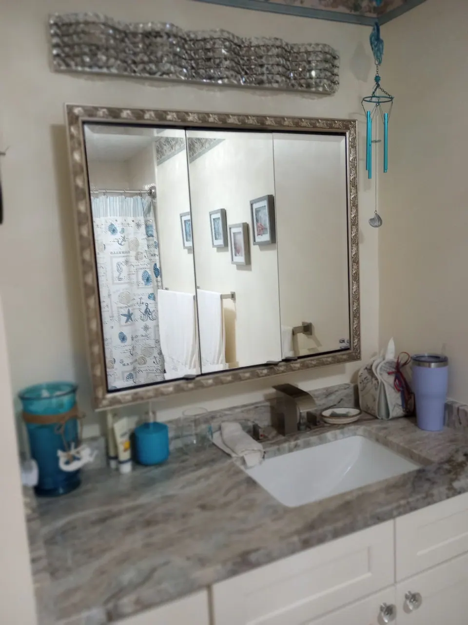 The vanity top and a framed mirror with the bathroom behind.