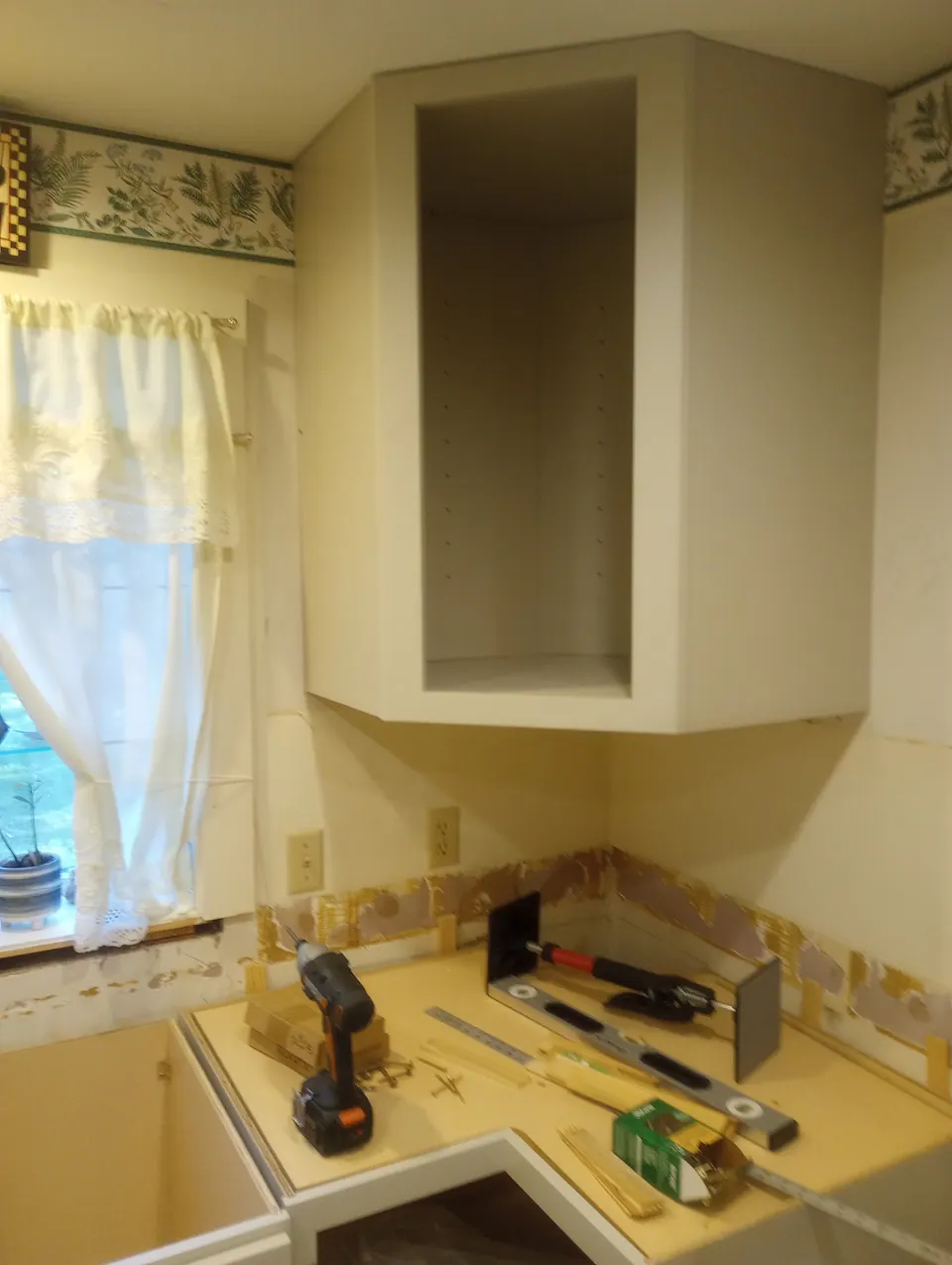 During the install: the old cabinets out, new corner wall cabinet up.