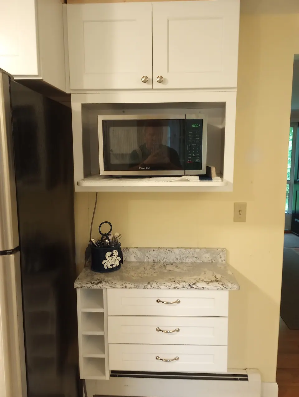 Microwave shelf over an open-end base with a granite top.