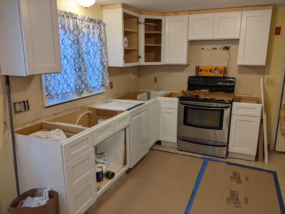 During the install: new white cabinets in, counters not yet set.