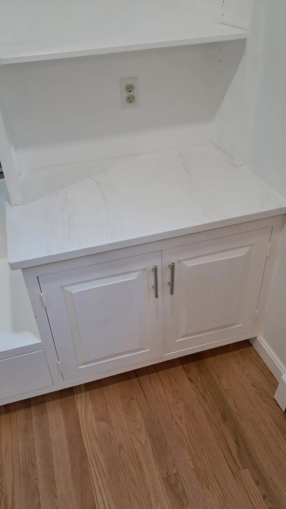 Dining room base cabinet with a marble-look top under an open bookcase.