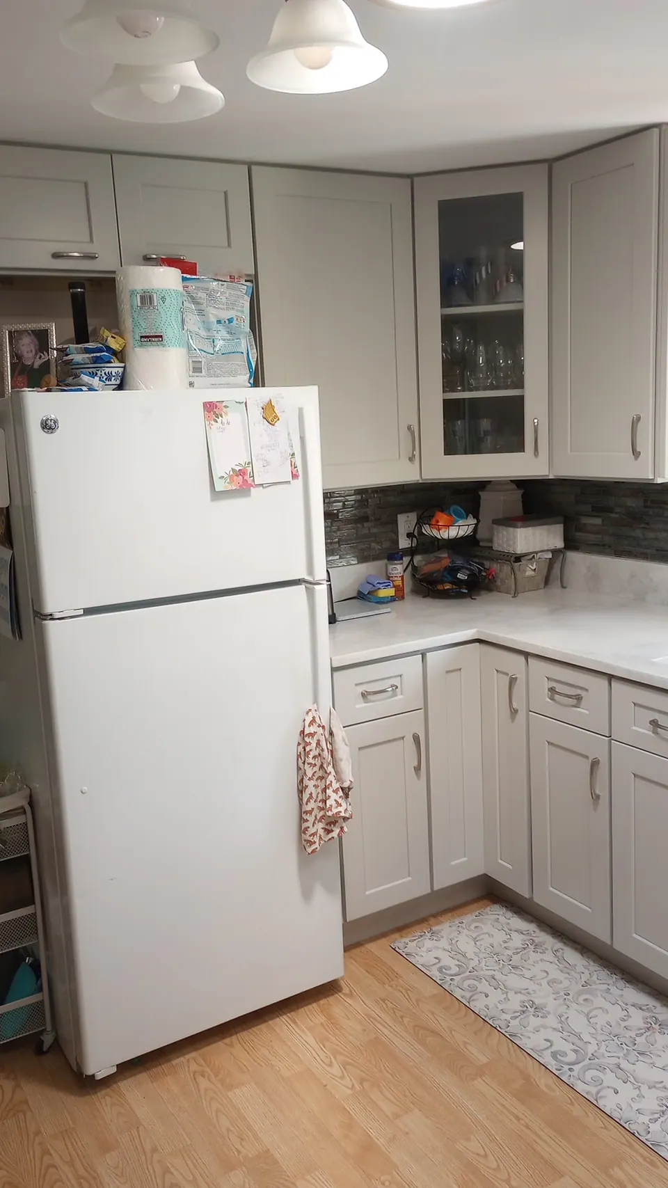 Kitchen corner with light gray cabinets and the refrigerator.