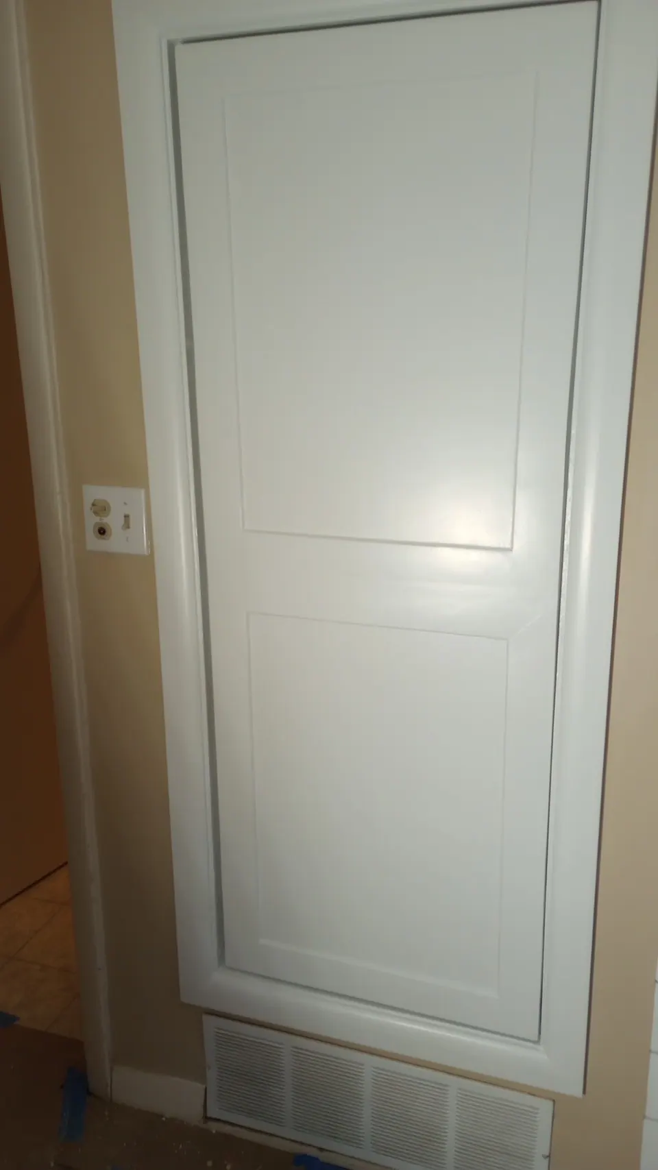 Tall white pantry cabinet beside the doorway.
