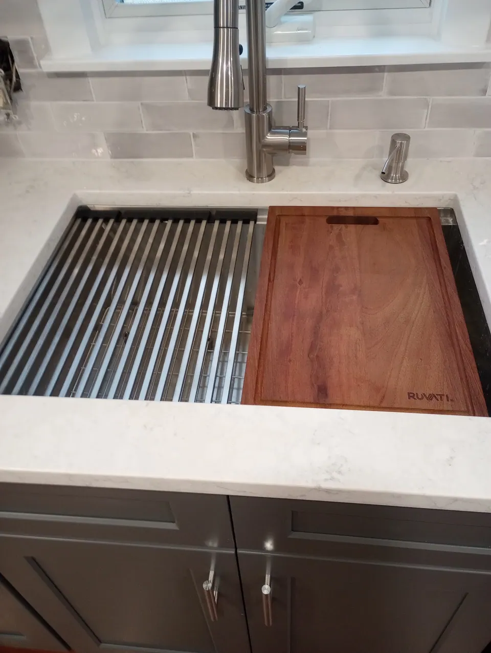 The same sink with a wood cutting board slid across it.