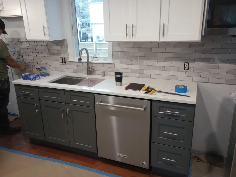 During the install: dark gray base cabinets and white wall cabinets in, counter and backsplash done.