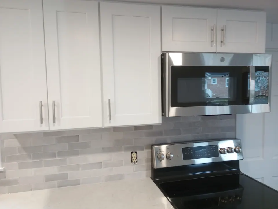 During the install: white wall cabinets and microwave over the range, tape still on the floor.