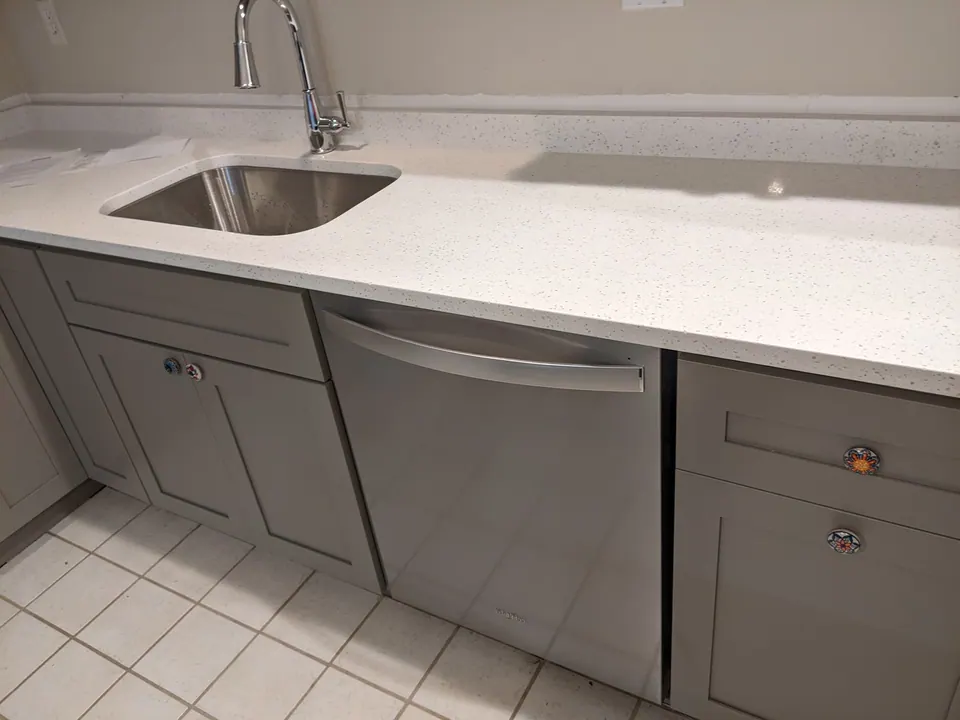 Sink run of gray shaker cabinets with the dishwasher.