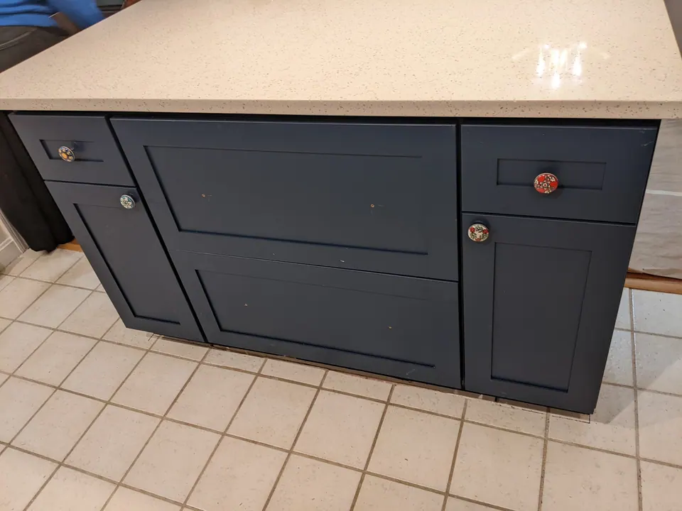 Navy shaker island with doors and a drawer.