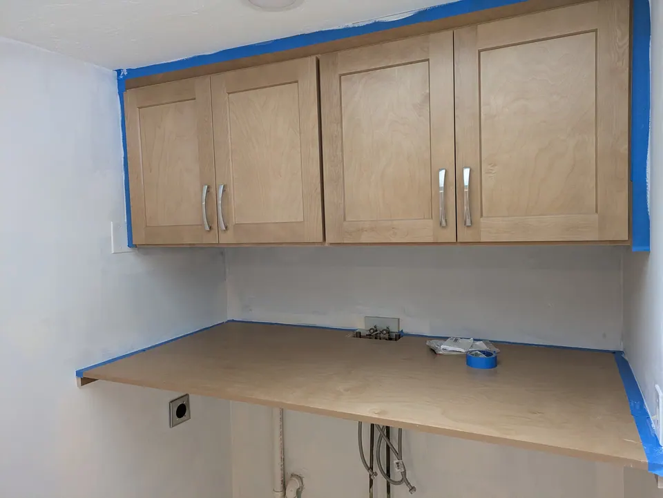Natural wood shaker wall cabinets over a floating wood counter.