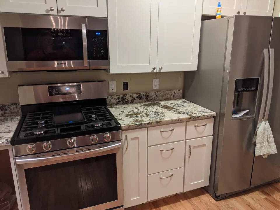 Gas range between white drawer bases with granite counters.