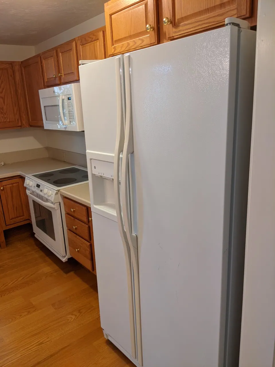 Before: oak cabinets around the range and refrigerator.