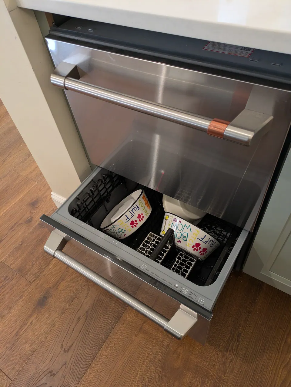 Drawer dishwasher built into the island, top drawer open.