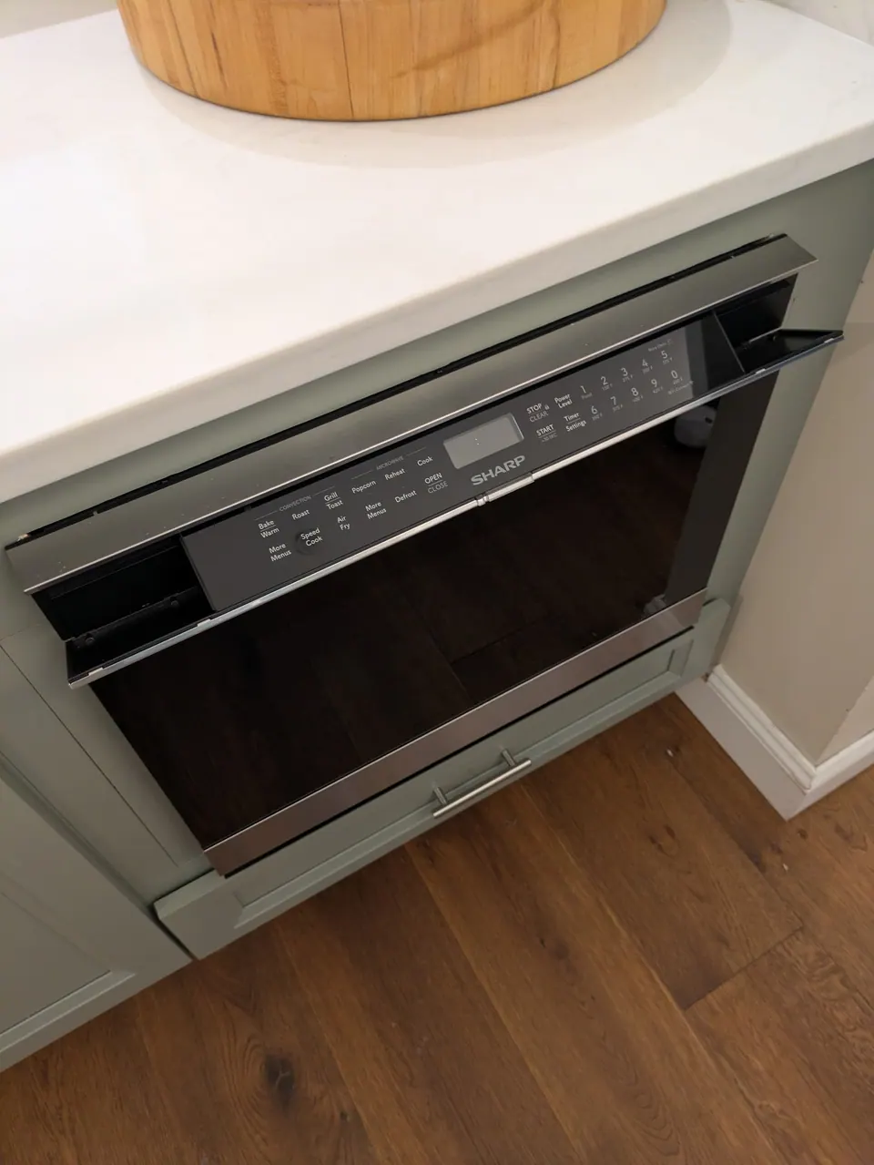 Built-in wall oven in a sage green island cabinet.