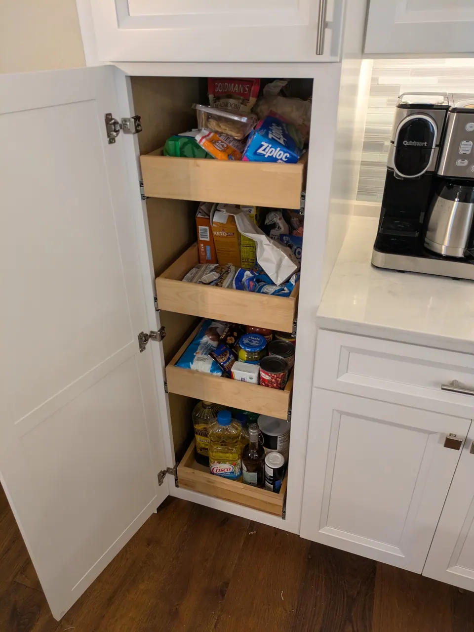 Tall pantry cabinet open with roll-out trays.