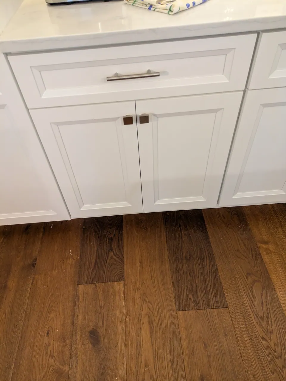 White drawer base cabinet with brushed nickel pulls.