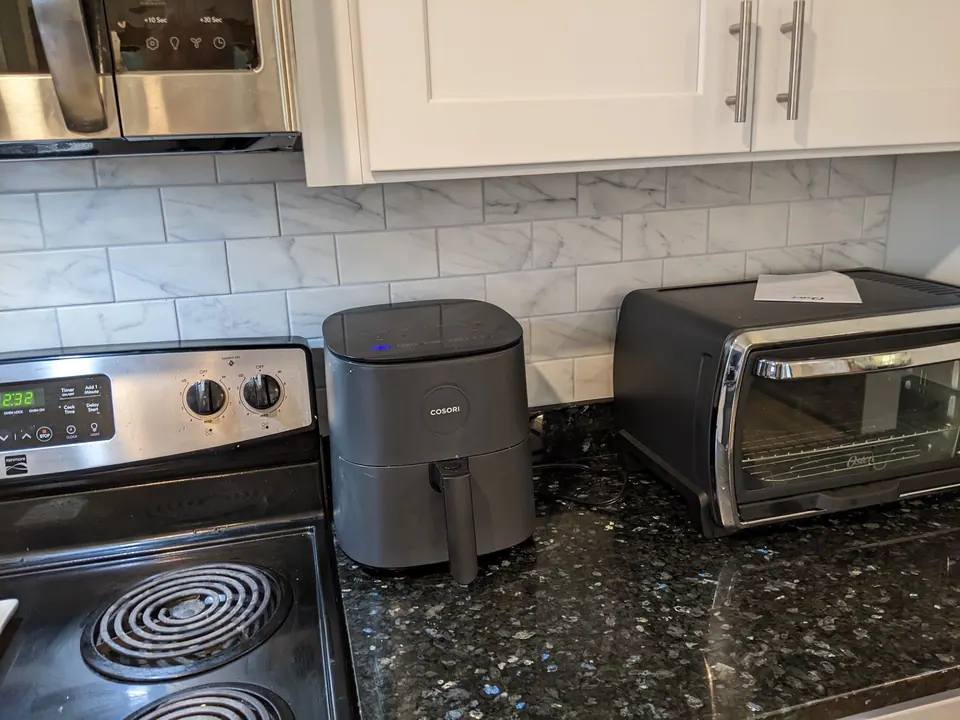 Black granite counter and white tile backsplash beside the range.