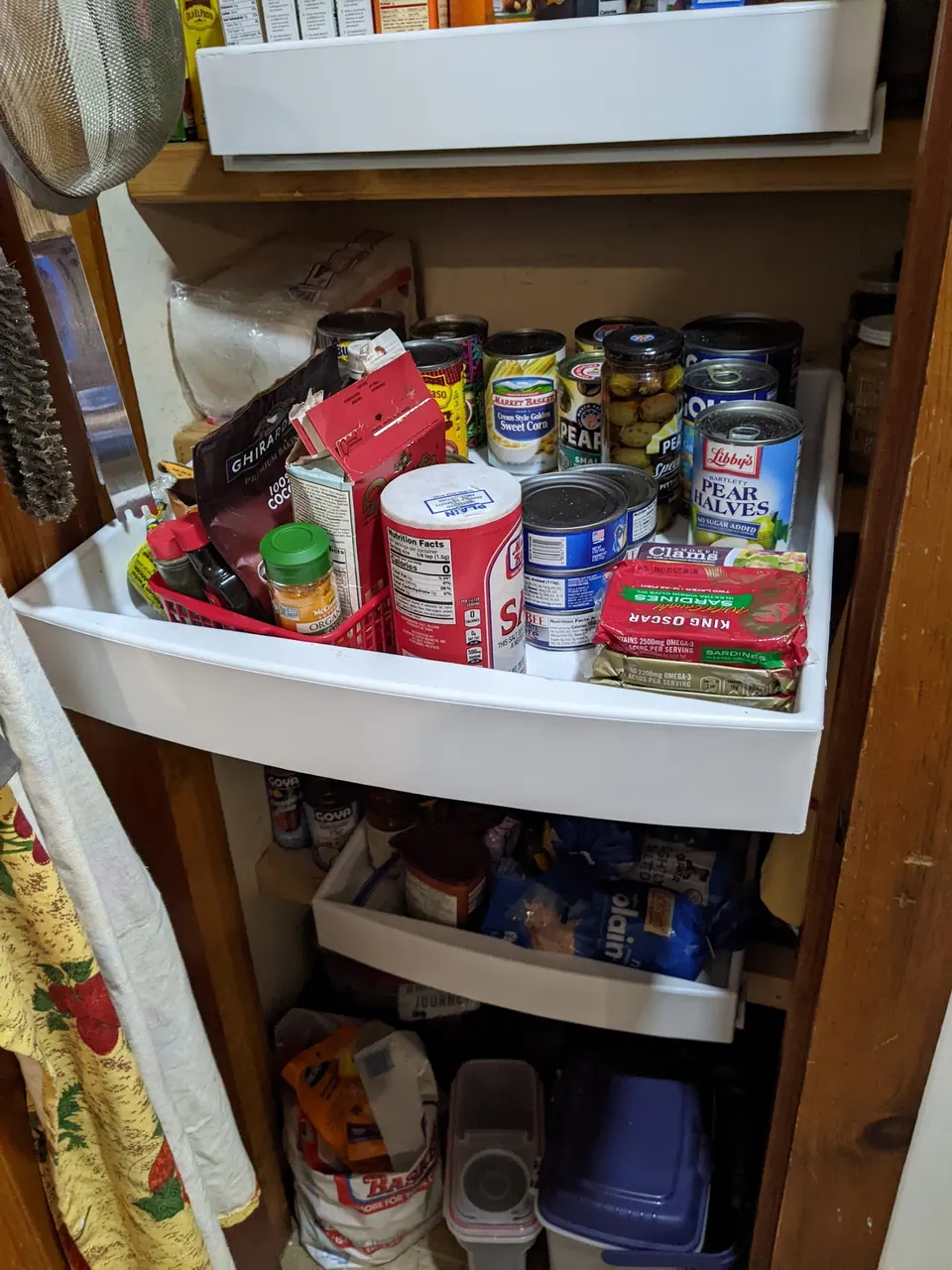 Pull-out pantry shelves full of groceries.
