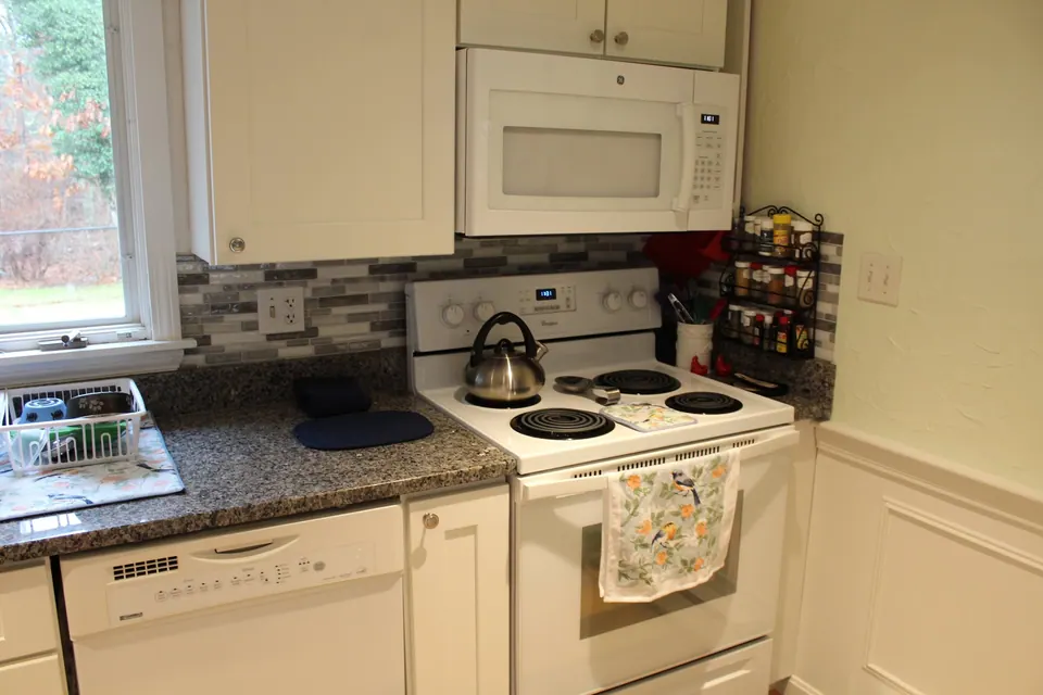 White range between white shaker cabinets and a tile backsplash.