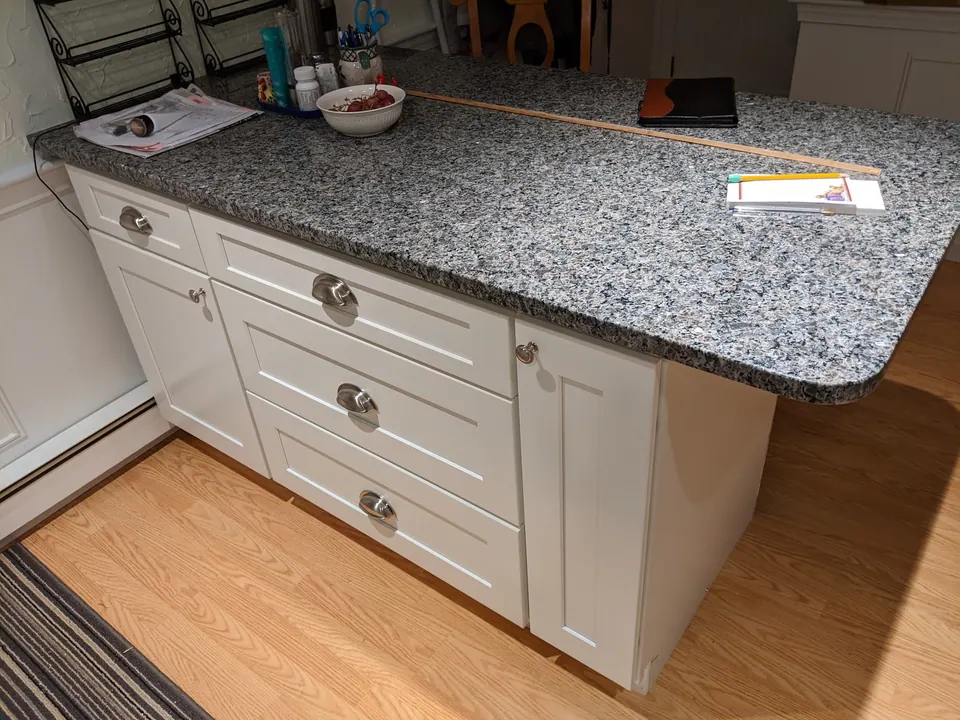White shaker base cabinets with a gray granite top.