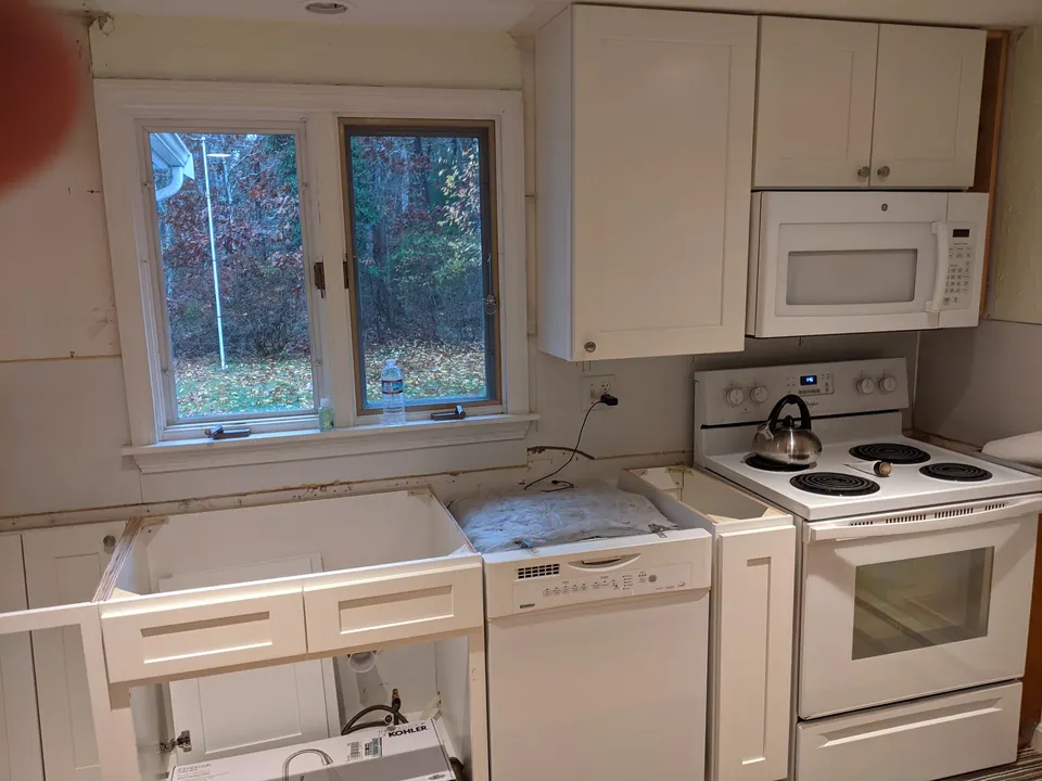 During the install: new white cabinets in, no counter yet.